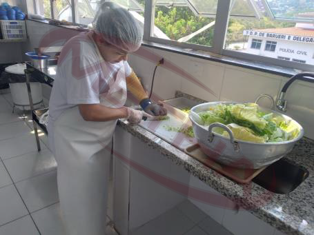 Funcionária preparando salada na cozinha